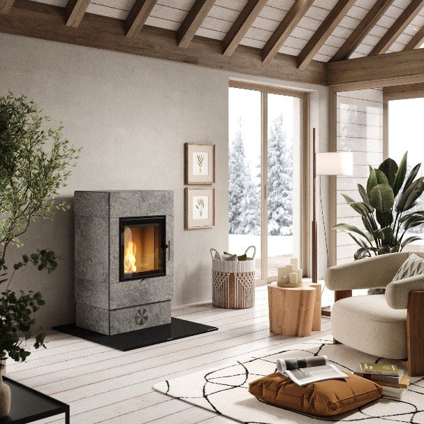Un soggiorno accogliente in stile scandinavo con una stufa pietra ollare Skantherm come elemento centrale, circondata da materiali naturali e molta luce.