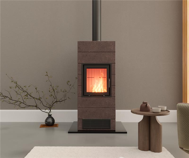 Una stufa pietra ollare moderna con il fuoco acceso, collocata accanto a un portalegna minimalista in un soggiorno.